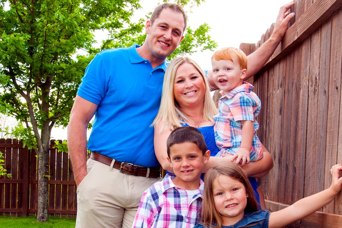 A family at their farm fence